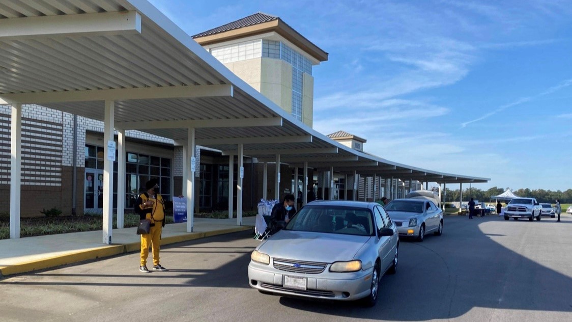 Cars line-up in front of a building.